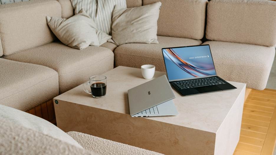 A person is sitting on a couch, working on a laptop and a tablet, with a mug and a cup on the table.

AI-generated content may be incorrect.